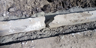 При ремонте тротуара устанавливают разбитый бортовой камень