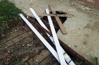 Сотрудники УК выкопали яму у детской площадки и прикрыли деревяшками