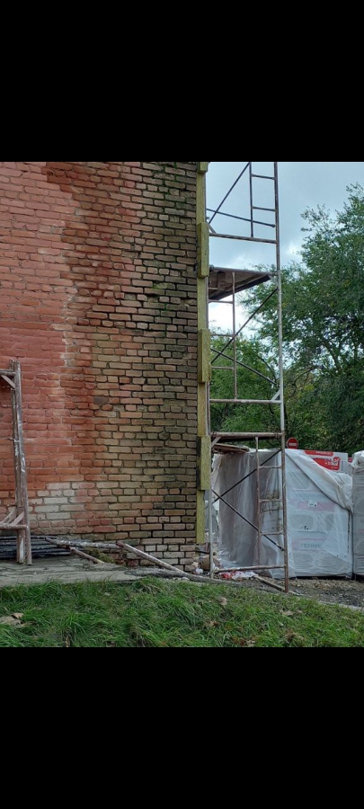 Строители ДК в Светлом заклеивают разрушающиеся стены утеплителем