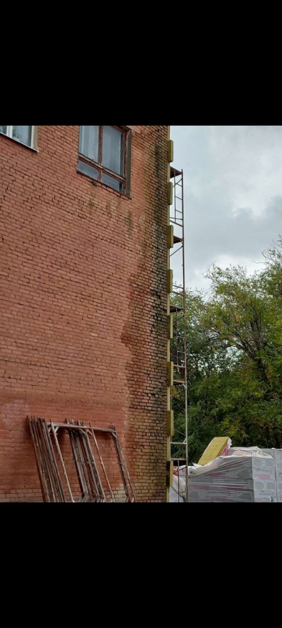 Строители ДК в Светлом заклеивают разрушающиеся стены утеплителем