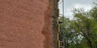 Строители ДК в Светлом заклеивают разрушающиеся стены утеплителем